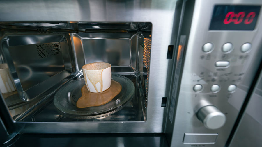 Dirty coffee cup after operating with microwave oven, heating water in microwave can be dangerous