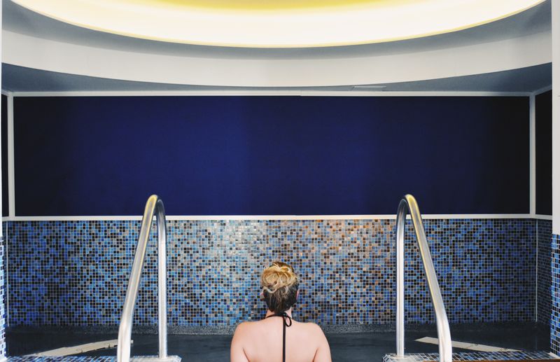 Rear view of woman sitting in a pool