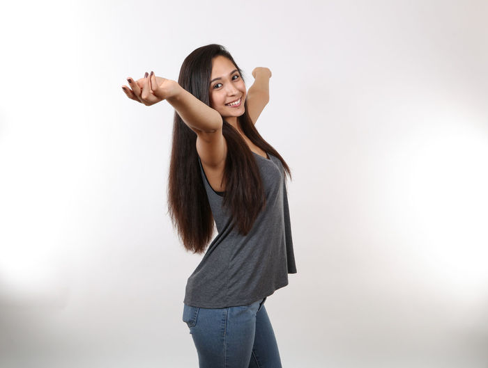 Full length of young woman standing against white background