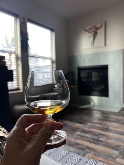 Hand holding a cognac glass  indoors 