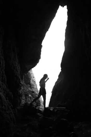 Silhouette man standing on rock formation
