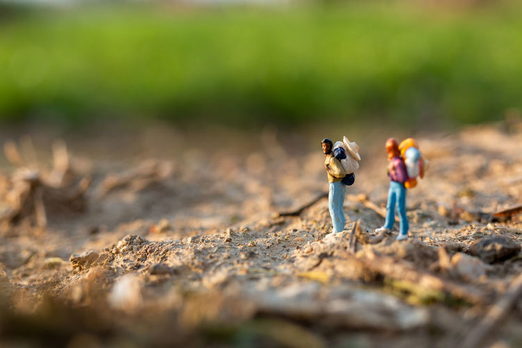 Miniature people backpackers walking with friends 