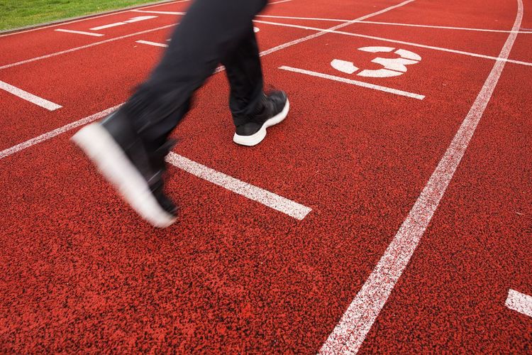 Red running racetrack on the stadium with two running legs