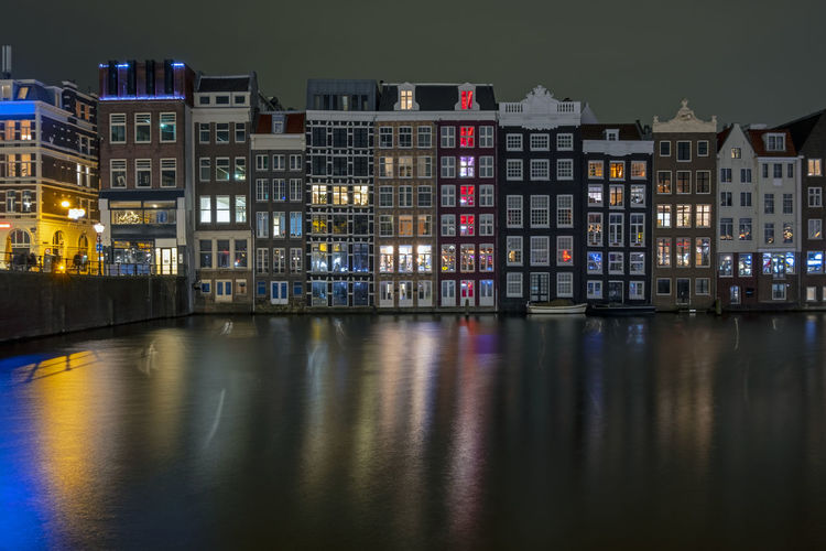 Traditonal houses at the damrak in amsterdam in the netherlands by night