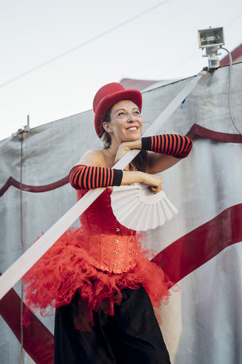 Female artist looking away while standing by circus tent
