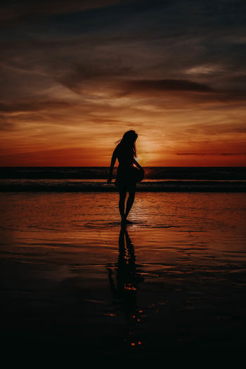 Paradise sunset woman silhouette. perfect amazing travel destination in indonesia, bali, kuta. 