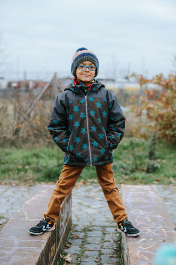 Portrait of cute boy wearing knit hat standing outdoors during winter