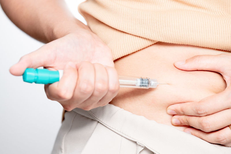 Midsection of doctor holding syringe