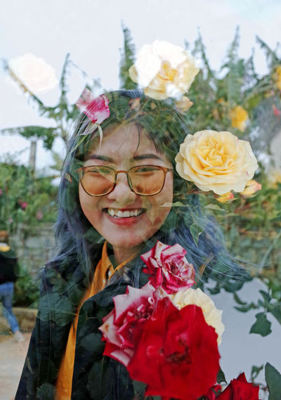 Portrait of a smiling young woman with red flower