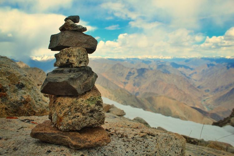Pieces of rocks balancing over another with a background of a mountains in ladakh and a copy space
