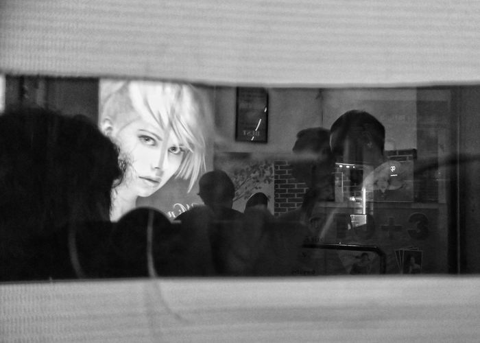 Portrait of woman looking through glass window