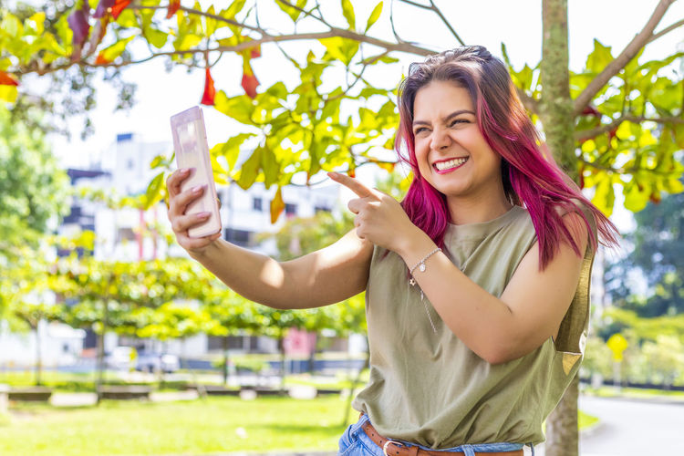 Portrait of a smiling young woman holding smart phone