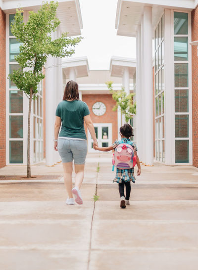Young millennial mother sending daughter off back to school