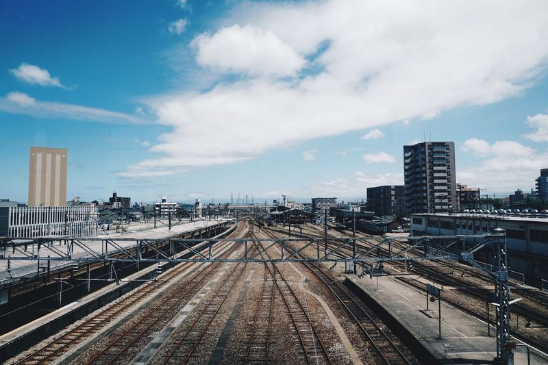 Railroad tracks amidst buildings against sky