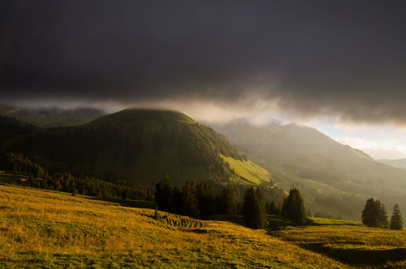 Scenic view of landscape and mountains against cloudy sky