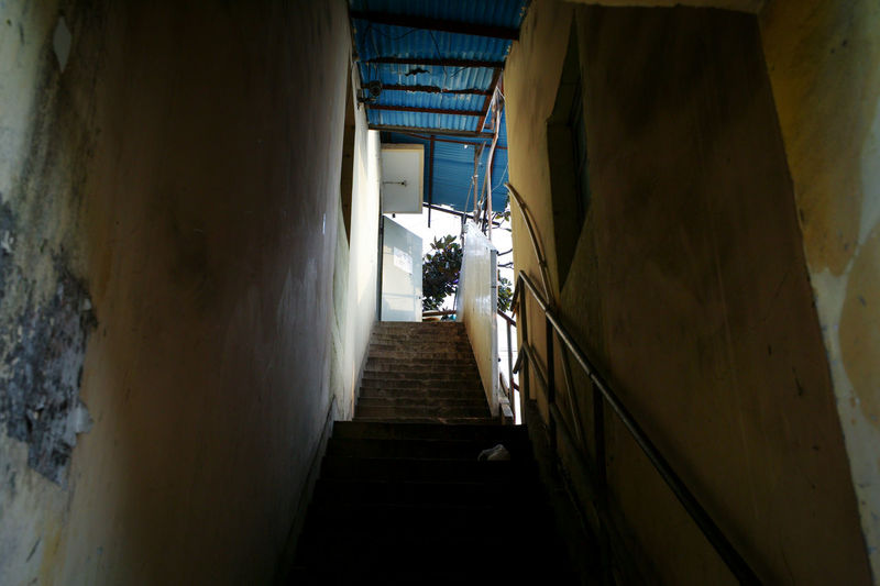 Rear view of man walking on narrow alley