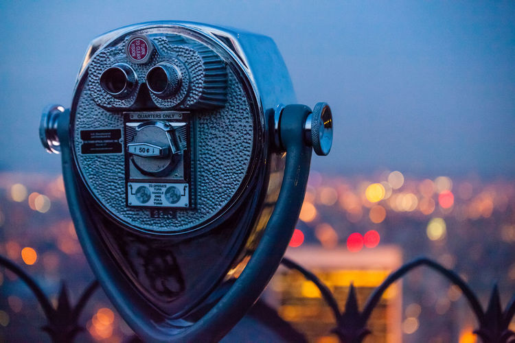 Close-up of coin-operated binocular against sky at dusk