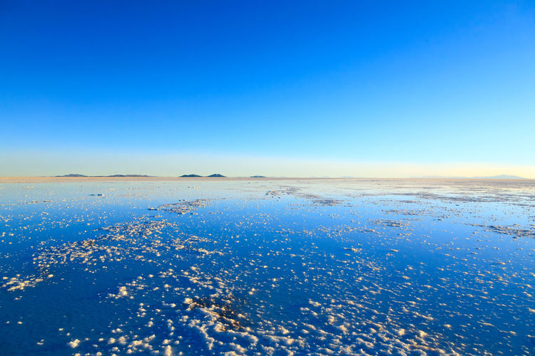 Scenic view of snow covered landscape against clear blue sky