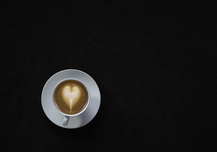 Directly above shot of coffee on table against black background