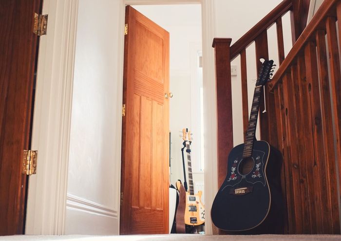 Guitar by wooden railing at home