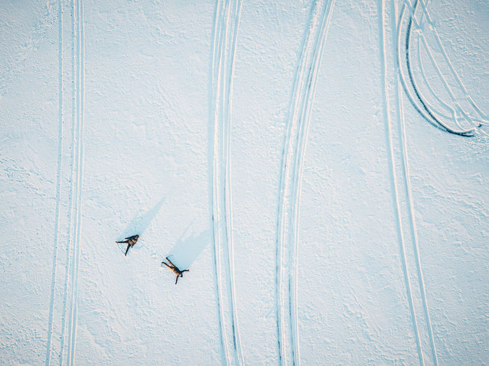High angle view of people lying down on snow