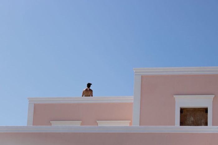 Low angle view of man on terrace against clear sky