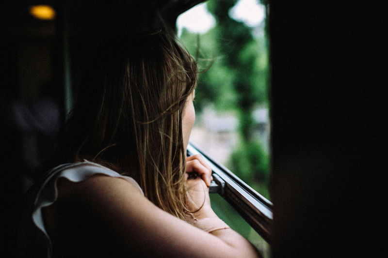 Close-up of woman looking through bus window
