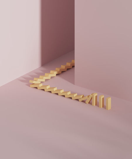 Studio shot of falling domino pieces placed around corner