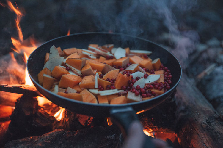 Frying pan over campfire with vegetables