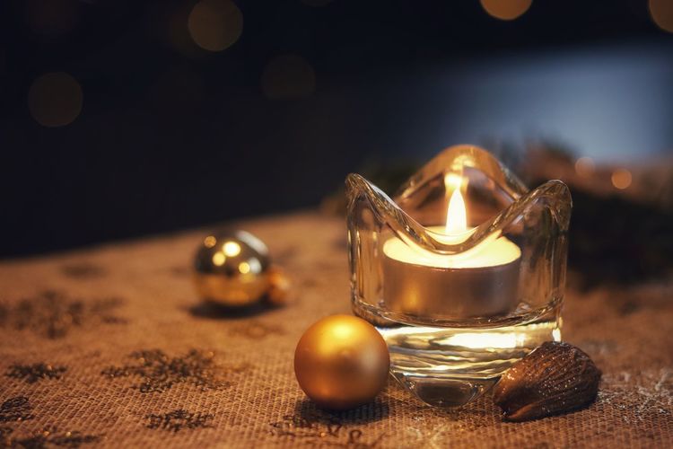 Close-up of illuminated tea light on table