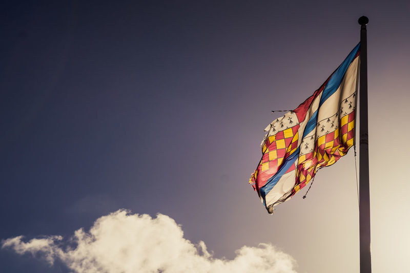 Colourful flag against a blue sky