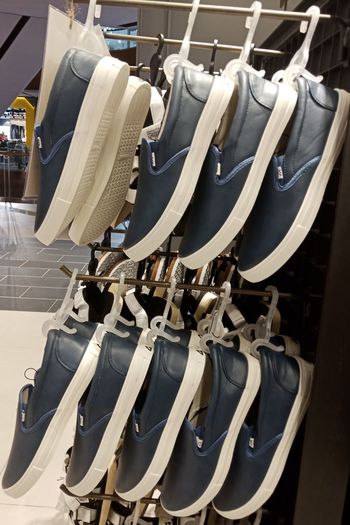 Close-up of shoes hanging on racks at store