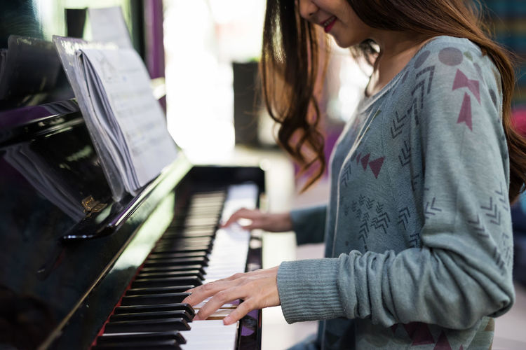 Midsection of woman playing piano