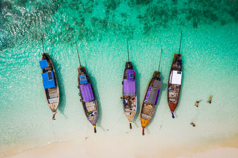 High angle view of longtail boats moored at shore of beach