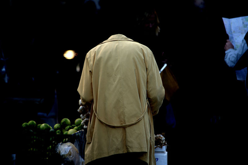 Rear view of man at street market during night