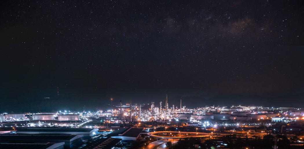 Blured for background  refinery area and lighting at night behind is the sky and galaxy starlight 