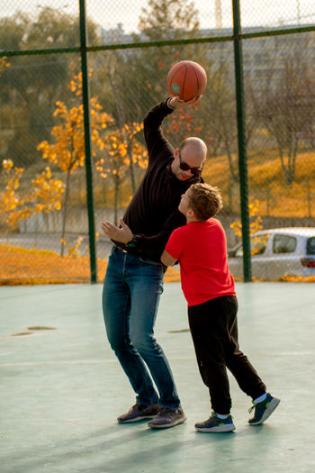 Full length of friends playing with ball