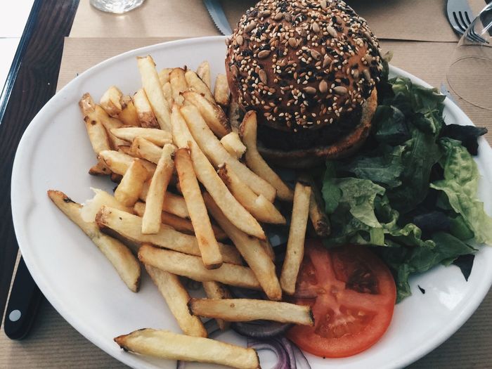 High angle view of burger and french fries in plate on table