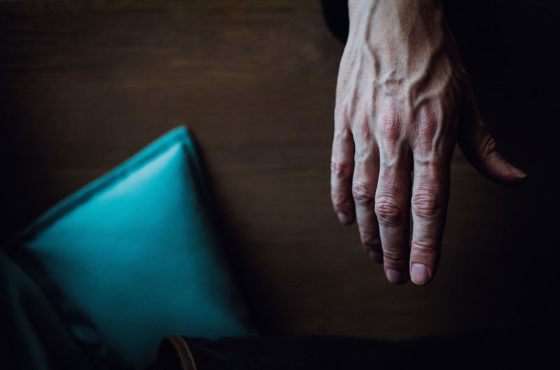 Cropped hand of man over wooden table