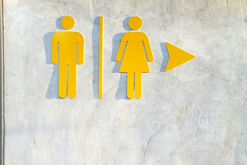 Male and female symbol on wall of restroom