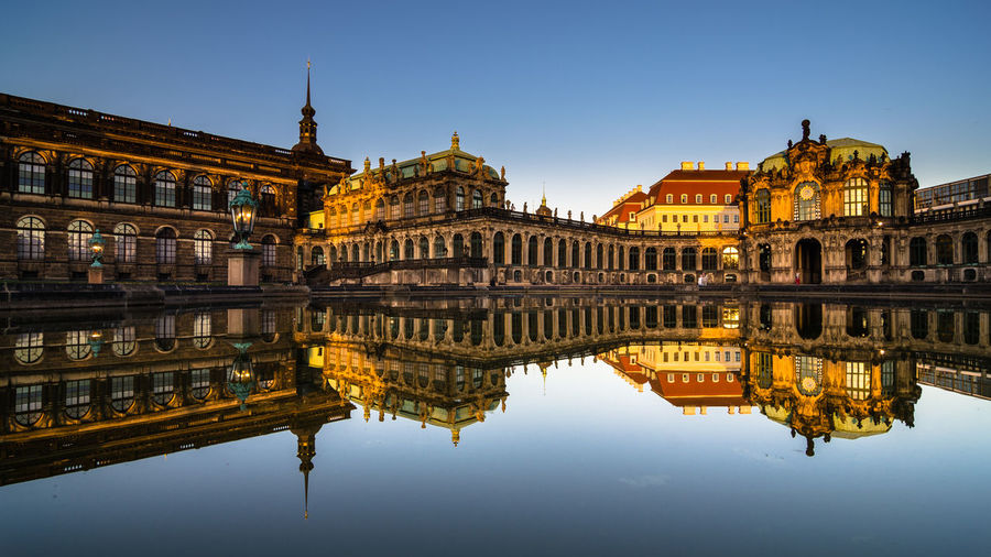 Reflection of historical building in lake against clear sky