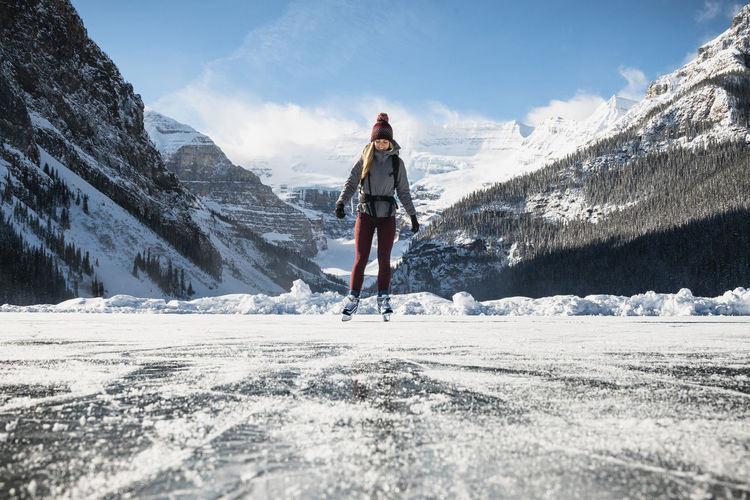 Woman ice skating on frozen lake at lake louse in banff national park