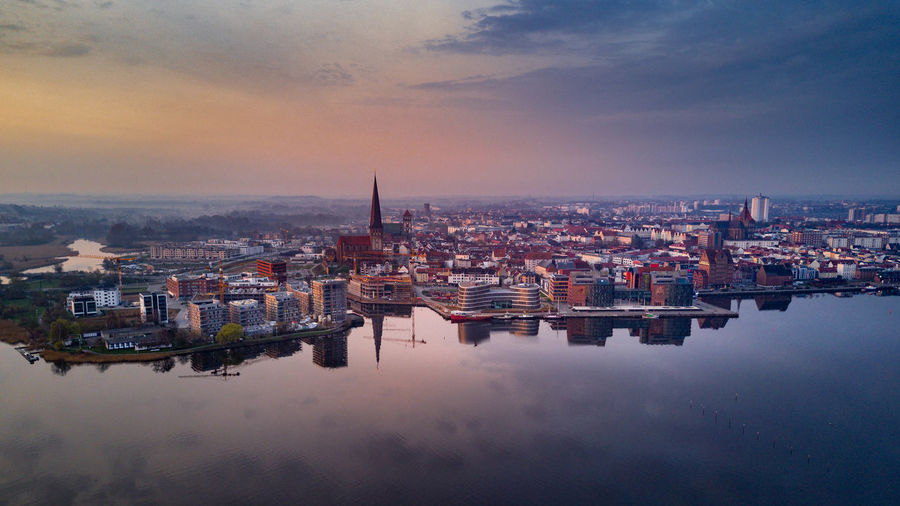 High angle view of buildings against cloudy sky during sunset