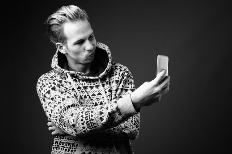 Man taking selfie against black background