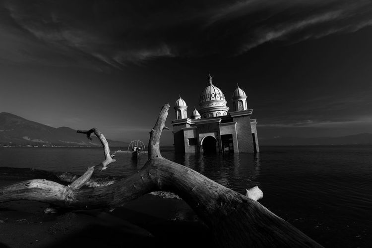 Low angle view of mosque in lake against sky