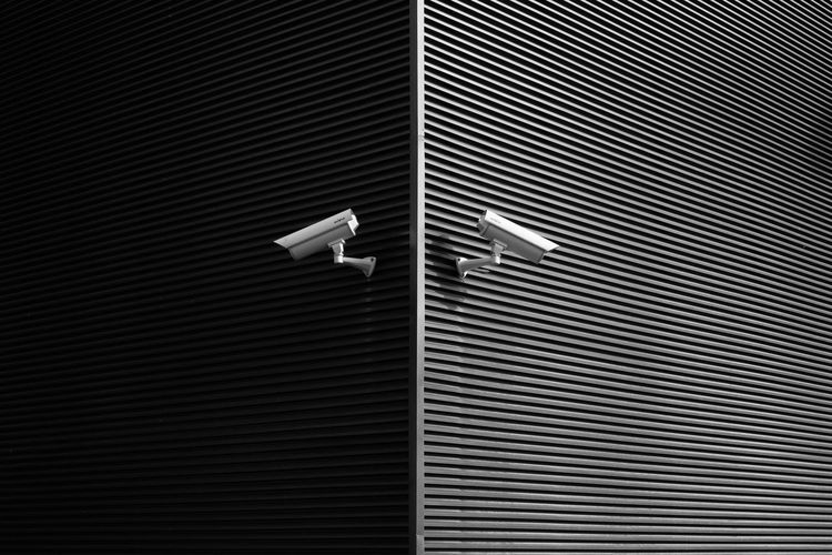 Low angle view of security cameras on wall