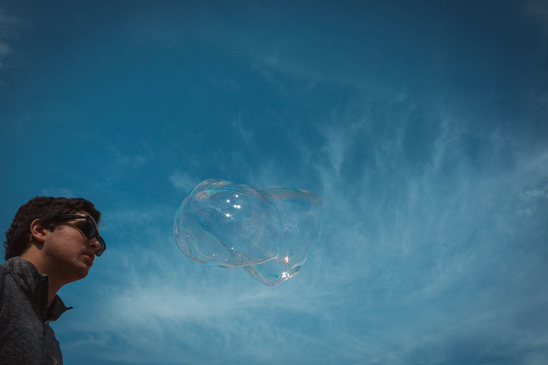 Low angle view of man by bubble against sky