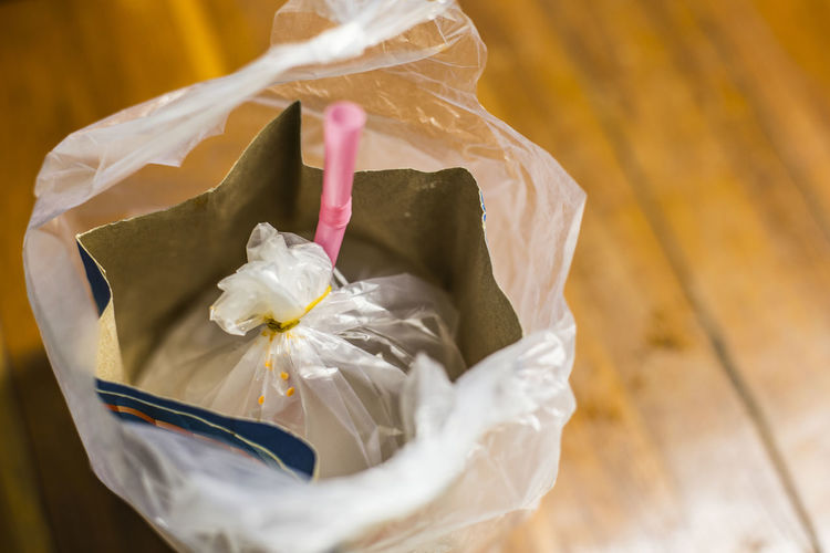 High angle view of package in plastic on hardwood floor at home