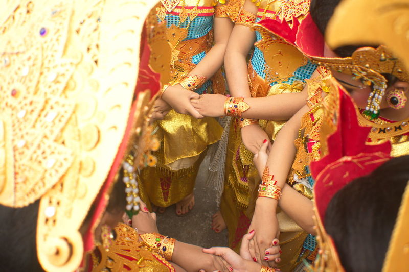 Traditional dancers from bali, indonesia pray while holding hands before performing.