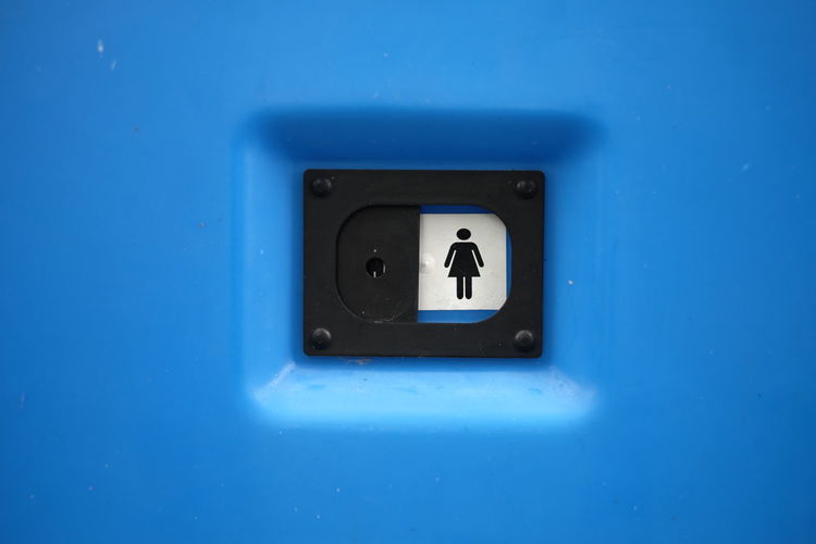 Women room sign on blue metallic wall